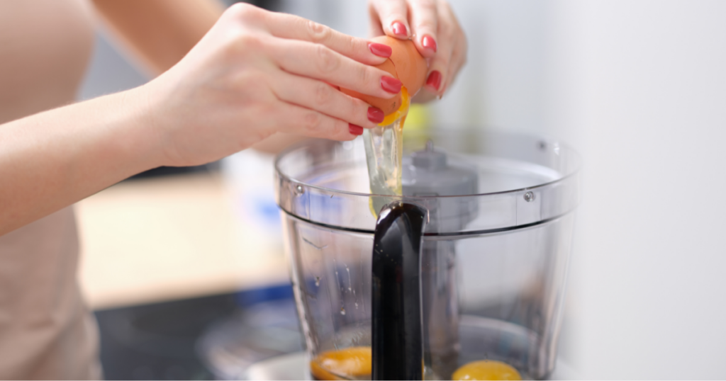 quebrando um ovo dentro do liquidificador para fazer a massa da torta